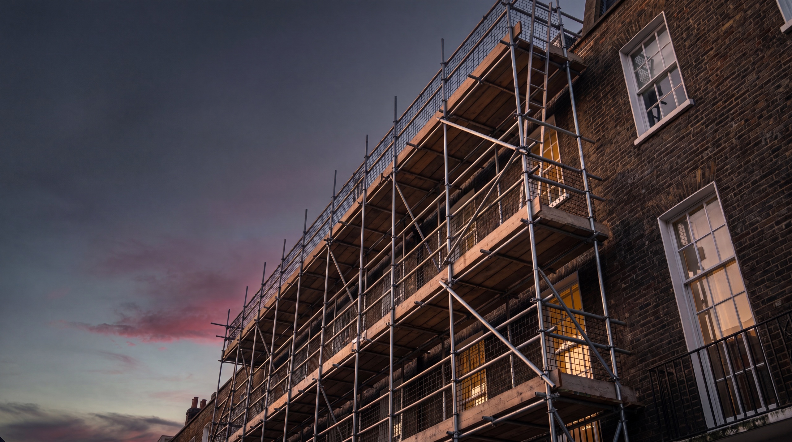 Multi-storey residential scaffolding erected by Rocket Scaffolding in Surrey at dusk
